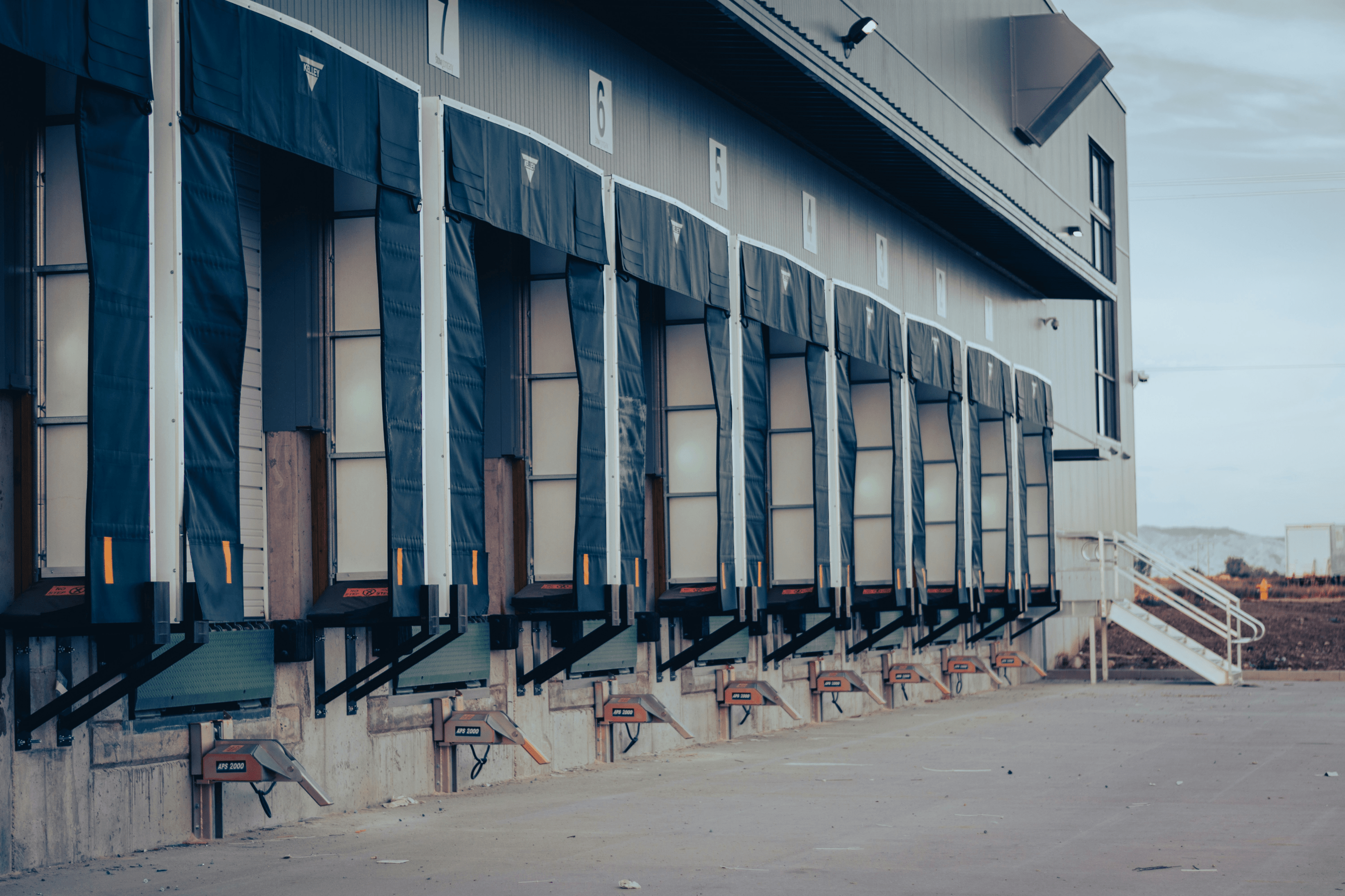 Exterior of a contract manufacturing facility with a row of loading docks for efficient transport of products.