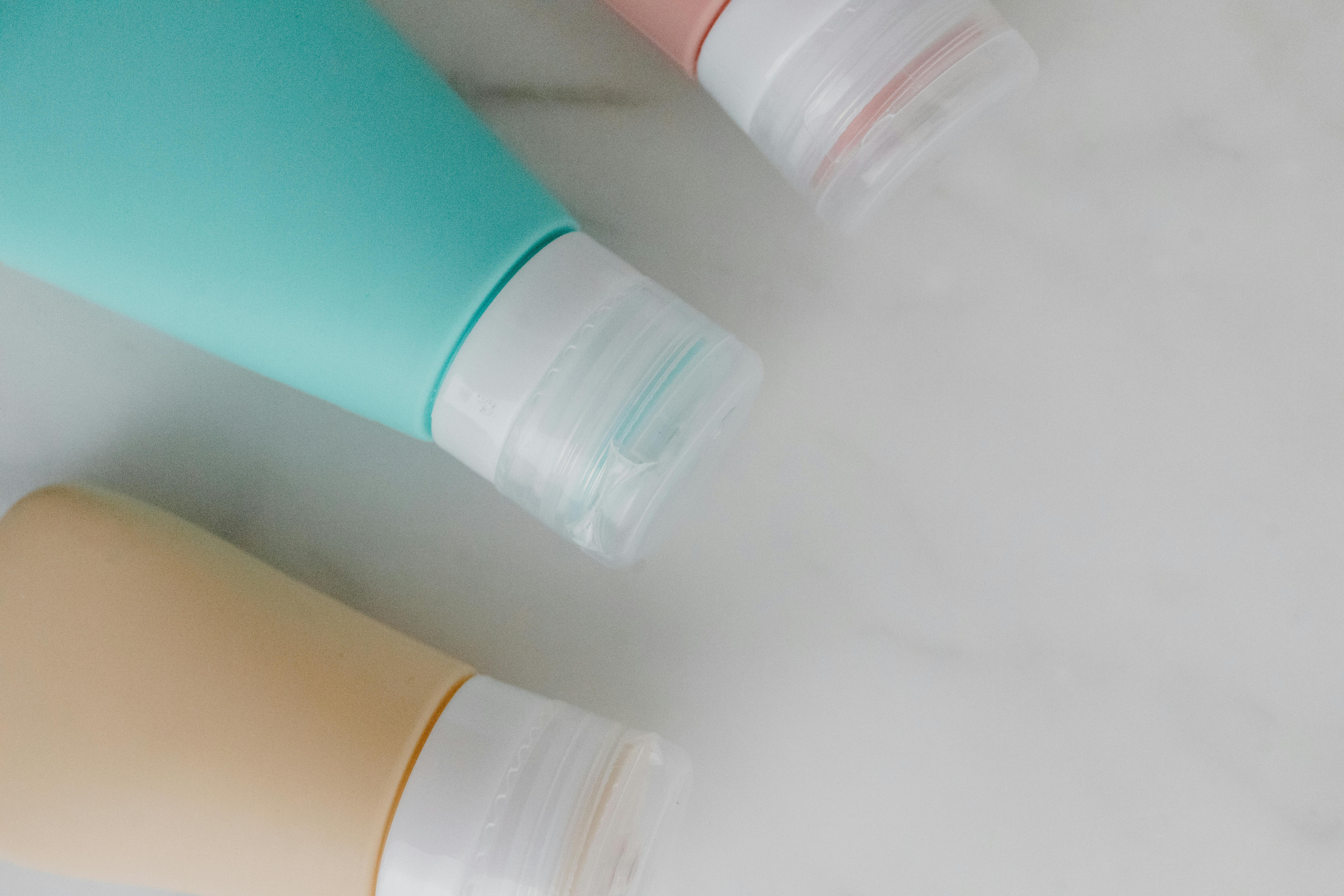 Three plastic bottles with different colored liquids.